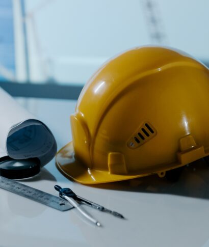 Yellow helmet hat in the project at construction site building oт a table. Building concept. Vertical image.